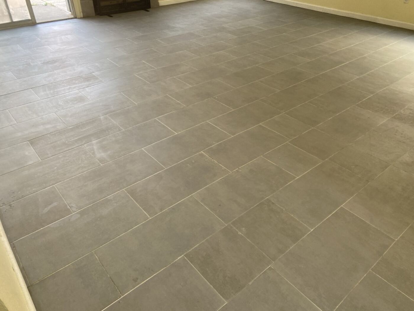 Clean grey tile floor in empty residential room after Timla care