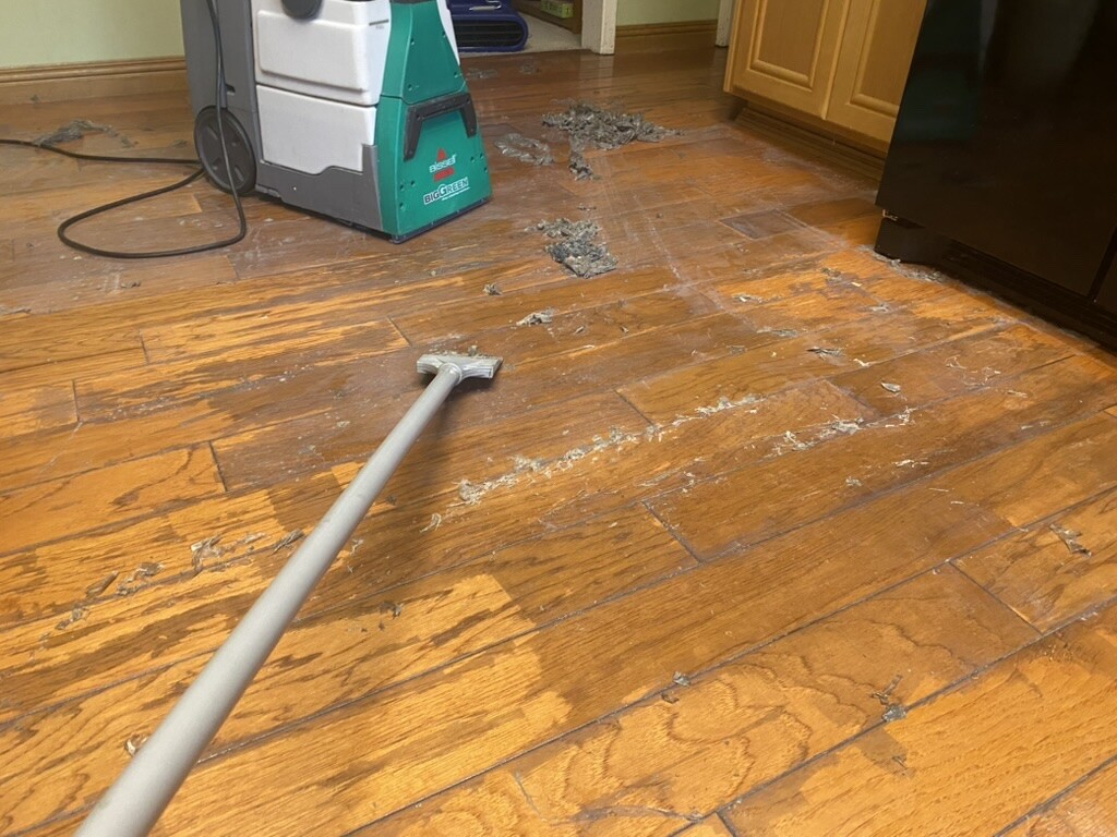 Scraping old wax buildup from residential hardwood during removal